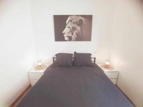 - une chambre avec un lit avec une photo de lion dans l'établissement AppartementCosy, cœurdeSouillac tidordognehomes, à Souillac