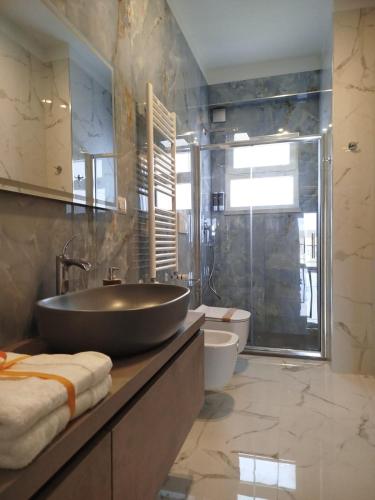 a bathroom with a large sink and a shower at Luxury Melo Apartment in Bari