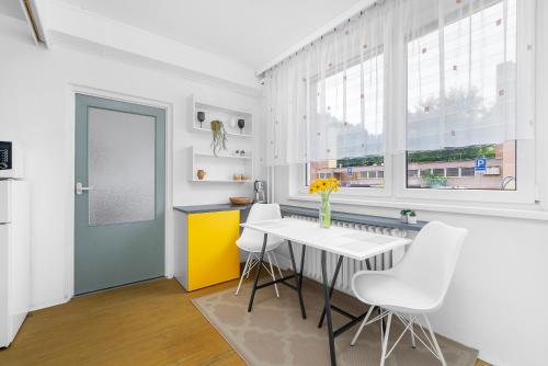 a kitchen with a white table and white chairs at One-bedroom apartment Řečkovice in Medlánky