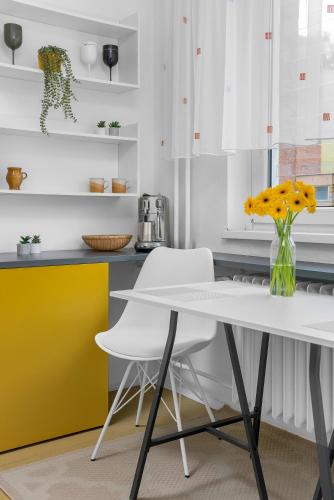a kitchen with a white table and two white chairs at One-bedroom apartment Řečkovice in Medlánky