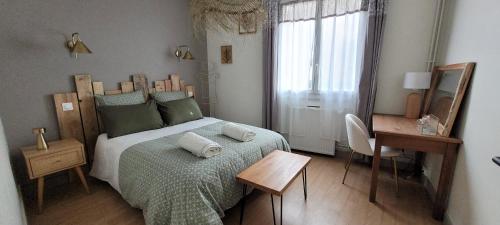 une chambre avec un lit, une table et une fenêtre dans l'établissement appartement cosy et confortable, à Tulle
