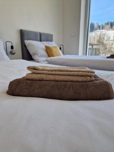 two beds with towels sitting on top of a bed at BREZOVINA Apartmán Pohoda Orava in Veselé