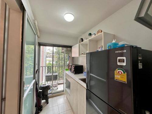 a kitchen with a stainless steel refrigerator and a balcony at DCondo Hyde near Central Plaza with Pool and Gym in Ban San Ton Ko (1)