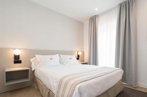a bedroom with a large white bed and a window at La Caleta QE Hotels in Cádiz