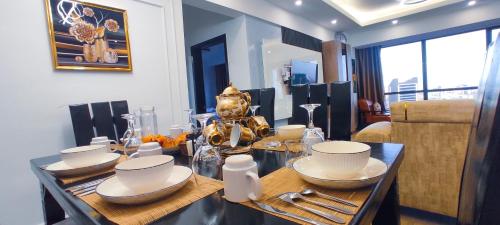 a dining room with a table with dishes on it at Stone Age Nairobi --- Rooftop Pool & Lounge, Gym, Games room, Office Space in Nairobi