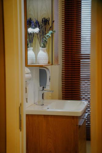 a bathroom with a sink and a vase of flowers at Leila Mansion Hotel in Tekirdağ