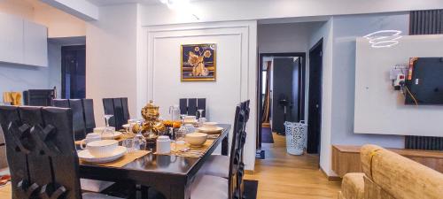 a dining room with a table with chairs and a tableablish at Stone Age Nairobi --- Rooftop Pool & Lounge, Gym, Games room, Office Space in Nairobi