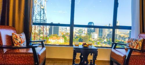 a room with two chairs and a table in front of a window at Stone Age Nairobi --- Rooftop Pool & Lounge, Gym, Games room, Office Space in Nairobi