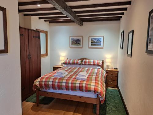 una camera da letto con un letto con due comodini e due lampade di Oakside Cottage Braithwaite a Braithwaite
