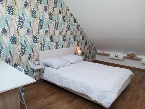 - une chambre avec un lit blanc et un mur dans l'établissement Maison spacieuse, élégante et moderne, à Mer