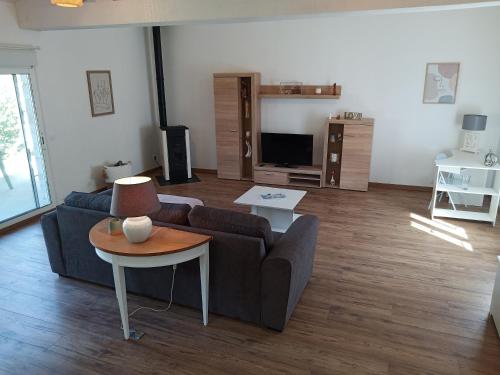 un salon avec un canapé et une table dans l'établissement Maison spacieuse, élégante et moderne, à Mer
