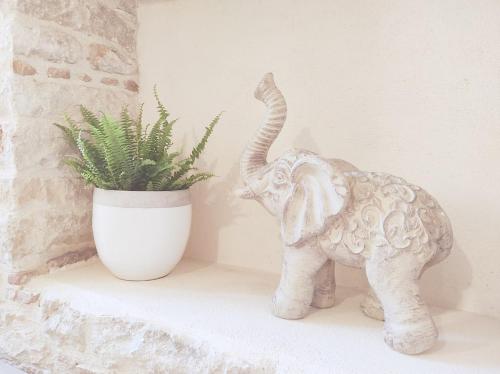 Une statue d'un éléphant debout à côté d'une plante dans l'établissement Charmant studio, cœurdeSouillac tidordognehomes, à Souillac