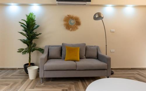 a living room with a couch with a yellow pillow at BIRD NEST Near Arkan Plaza in Cairo