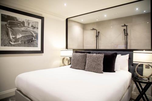 a bedroom with a large white bed and a picture of a car at The Hotel Chester in Chester