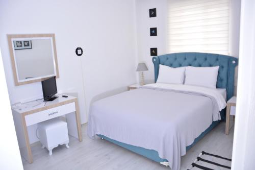 a bedroom with a bed and a desk with a computer at Bilge Suite Hotel in Corum