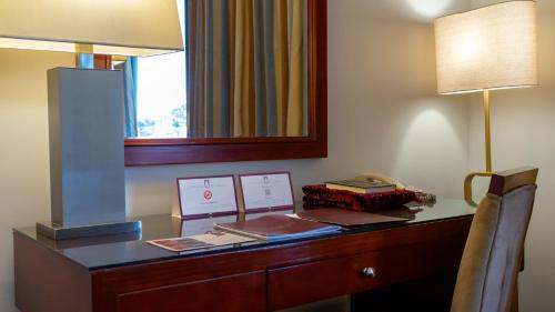 a desk in a hotel room with a mirror and a lamp at فندق الصفوة البرج الثالث Al Safwah Hotel Third Tower 3 in Makkah