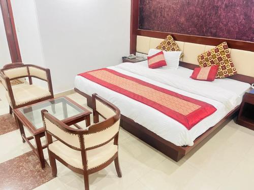 a bedroom with a bed and a chair and a glass table at HOTEL RAMA INN, New Delhi Station in New Delhi