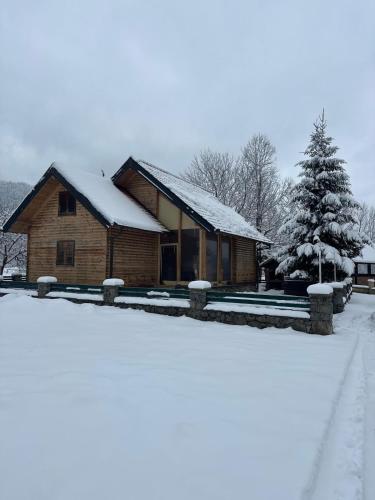 a log cabin with snow on the roof at Kuća za odmor Petra in Jasenak
