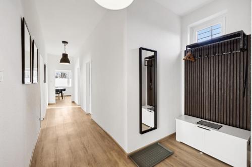 a hallway with white walls and a mirror at nobilis Apartment-6Pers-Zentrumsnah-Parkplatz-Netflix-Monteursgerecht in Meppen