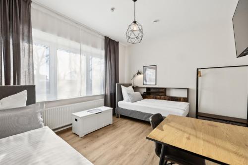 a hotel room with two beds and a table at nobilis Apartment-6Pers-Zentrumsnah-Parkplatz-Netflix-Monteursgerecht in Meppen
