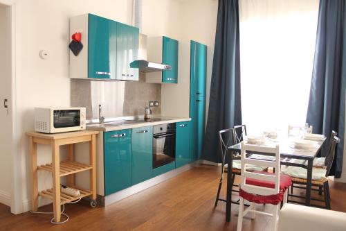 una cucina con armadi blu e un tavolo con forno a microonde di Art Apartment stazione A a Firenze