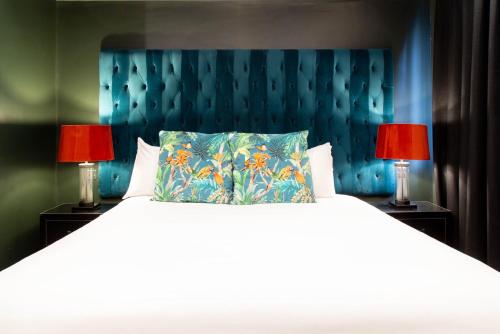 a bedroom with a large bed with two red lamps at The Hotel Chester in Chester
