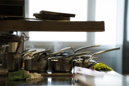 a group of pots and pans on a stove in a kitchen at Logis Restaurant & Hôtel À la 12 in Delme
