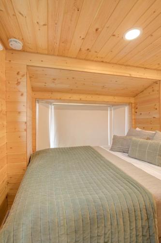 a bedroom with a bed in a wooden cabin at Cozy Loft Tiny House by Ocean Spray Beach in Grayland