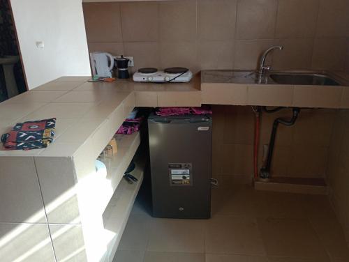 a small kitchen with a sink and a refrigerator at Keur Mamina in Warang