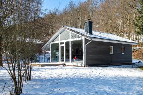 a small house in the snow with a snow covered yard at 4 Personen mit Sauna F0H4 in Ruhla