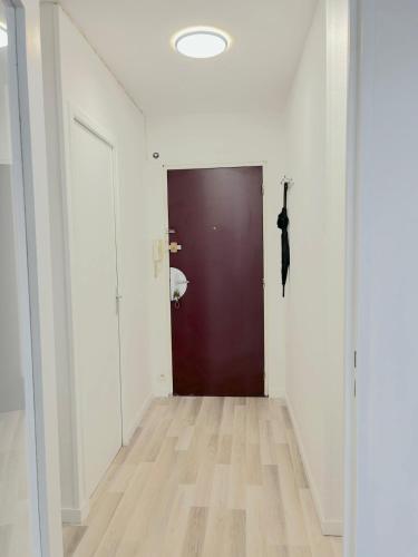 a hallway with a black door and a wooden floor at Appartement jusqu'à 4 Voyageurs in Villeneuve d'Ascq