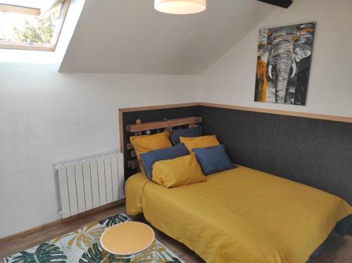 - une chambre avec un lit doté d'oreillers jaunes et bleus dans l'établissement AgréableStudio, cœurdeSouillac, tidordognehomes, à Souillac