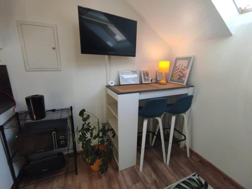 une pièce avec un bureau et une télévision au mur dans l'établissement AgréableStudio, cœurdeSouillac, tidordognehomes, à Souillac