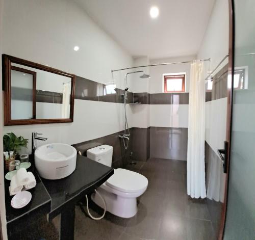 a bathroom with a toilet and a sink and a mirror at Pink house Homestay in Hoi An