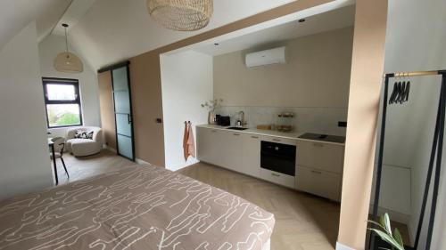 a bedroom with a large bed and a kitchen at B&B Smûk in Tietjerk