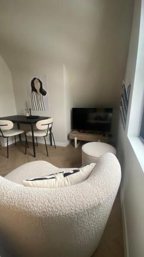 a living room with two white chairs and a table at B&B Smûk in Tietjerk