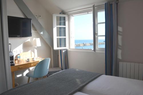 une chambre avec un lit, un bureau et une fenêtre dans l'établissement Hotel du Centre - Chez Janie, à Roscoff