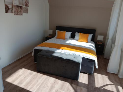 a bedroom with a large bed with orange pillows at Gästehaus Becker in Wachenheim an der Weinstraße