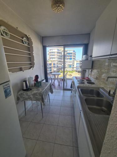 - une cuisine avec un évier et une table avec vue dans l'établissement Superbe T3 terrasse et vue mer - Islette du Riou - La Napoule, à Mandelieu-la-Napoule