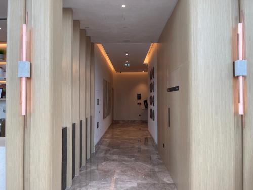 a hallway with white walls and a long hallway with columns at 1 Bedroom Apartment at Marassi Vista Residence in Muharraq