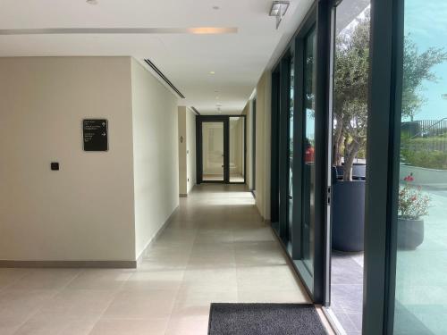 an empty hallway in a building with glass doors at 1 Bedroom Apartment at Marassi Vista Residence in Muharraq