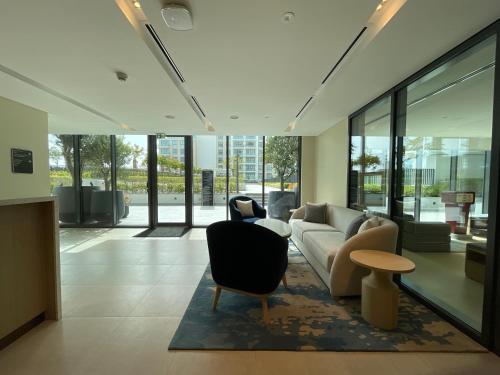 a living room with a couch and chairs and a table at 1 Bedroom Apartment at Marassi Vista Residence in Muharraq