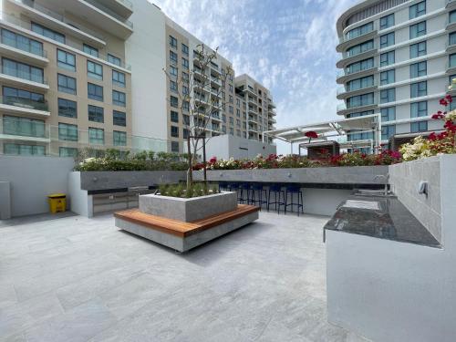 a courtyard in a building with tables and chairs at 1 Bedroom Apartment at Marassi Vista Residence in Muharraq