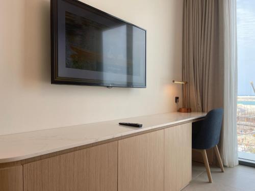 a flat screen tv hanging on a wall in a hotel room at 1 Bedroom Apartment at Marassi Vista Residence in Muharraq