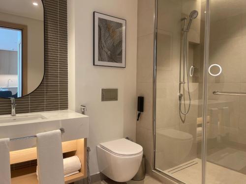 a bathroom with a shower and a toilet and a sink at 1 Bedroom Apartment at Marassi Vista Residence in Muharraq