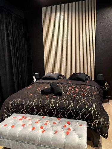 a bedroom with a bed with red flowers on it at Suite de Luxe - Jacuzzi & Cave Secrète in Saint-Quentin