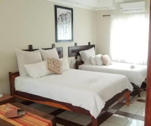 a bedroom with two beds and a window at Guest House Bavaria in Rundu