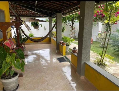 a porch with potted plants and a hammock at Temporada2 in Olinda