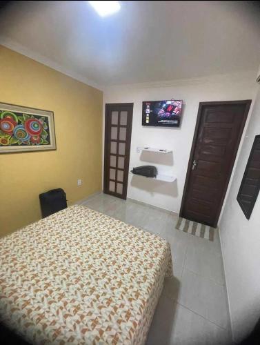 a bedroom with a bed and a tv on the wall at Temporada2 in Olinda