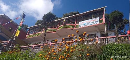 a building with a balcony on top of it at Mane Dara homestay in Darjeeling